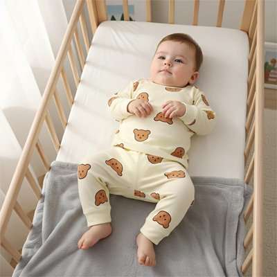 bébé allonger dans son lit avec pyjama bebe beige