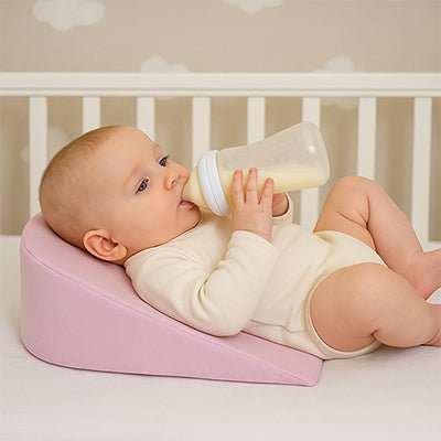 bébé allonger sur son Plan Incliné pour bébé rose bois son biberon