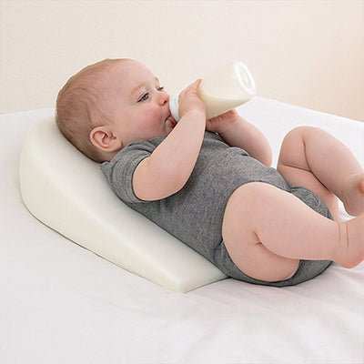 bébé allonger sur son Plan incliné pour bébé blanc
