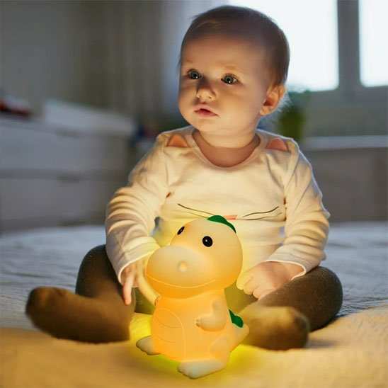 bebe assis a coter de sa veilleuse bébé 