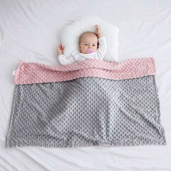 bébé couverte avec sa couverture bébé rose et gris