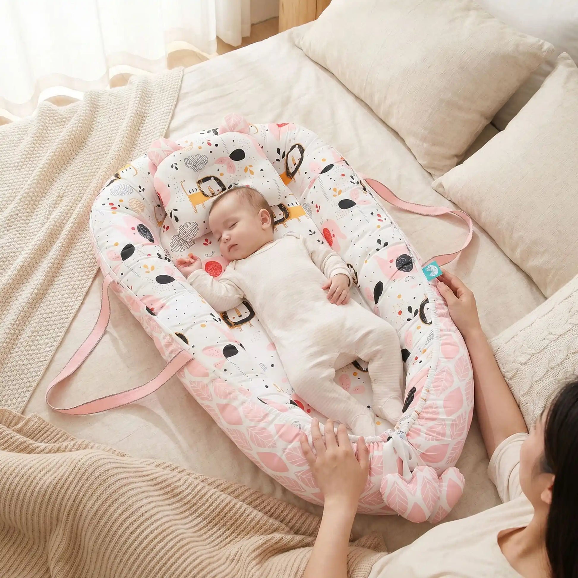 bébé dans son réducteur de lit bébé allonger a coter de sa maman