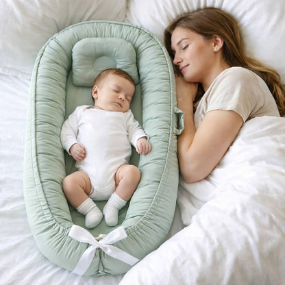 bébé dort a coter de sa maman dans son bébé réducteur de lit