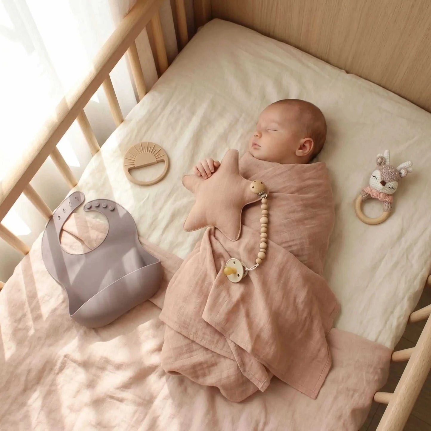 bébé dort avec son doudou en forme de cœur rose dans les mains
