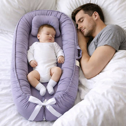 bebe dort dans son bebe reducteur de lit a coter de son papa