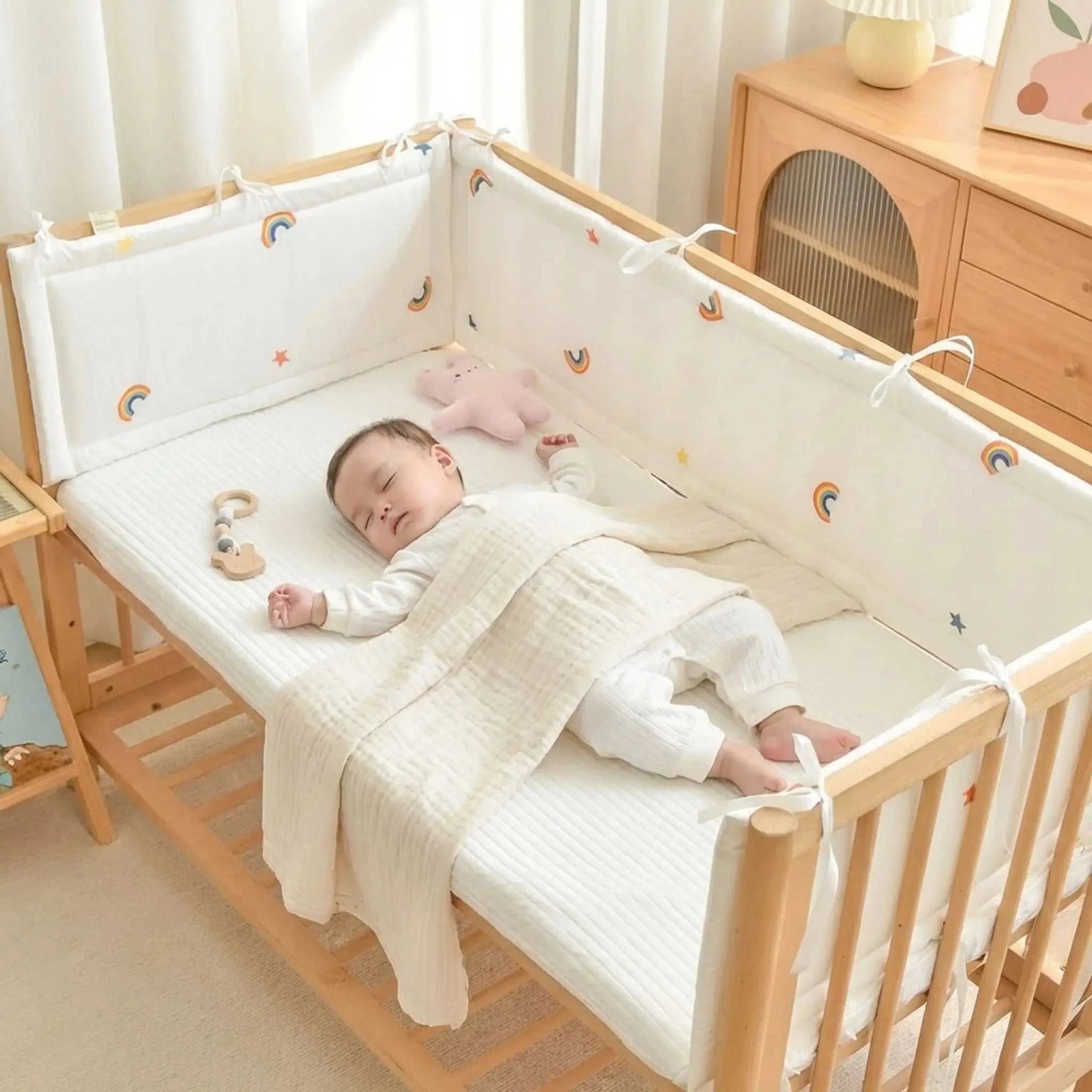 bébé endormis entourer de tour de lit bebe arc en ciel