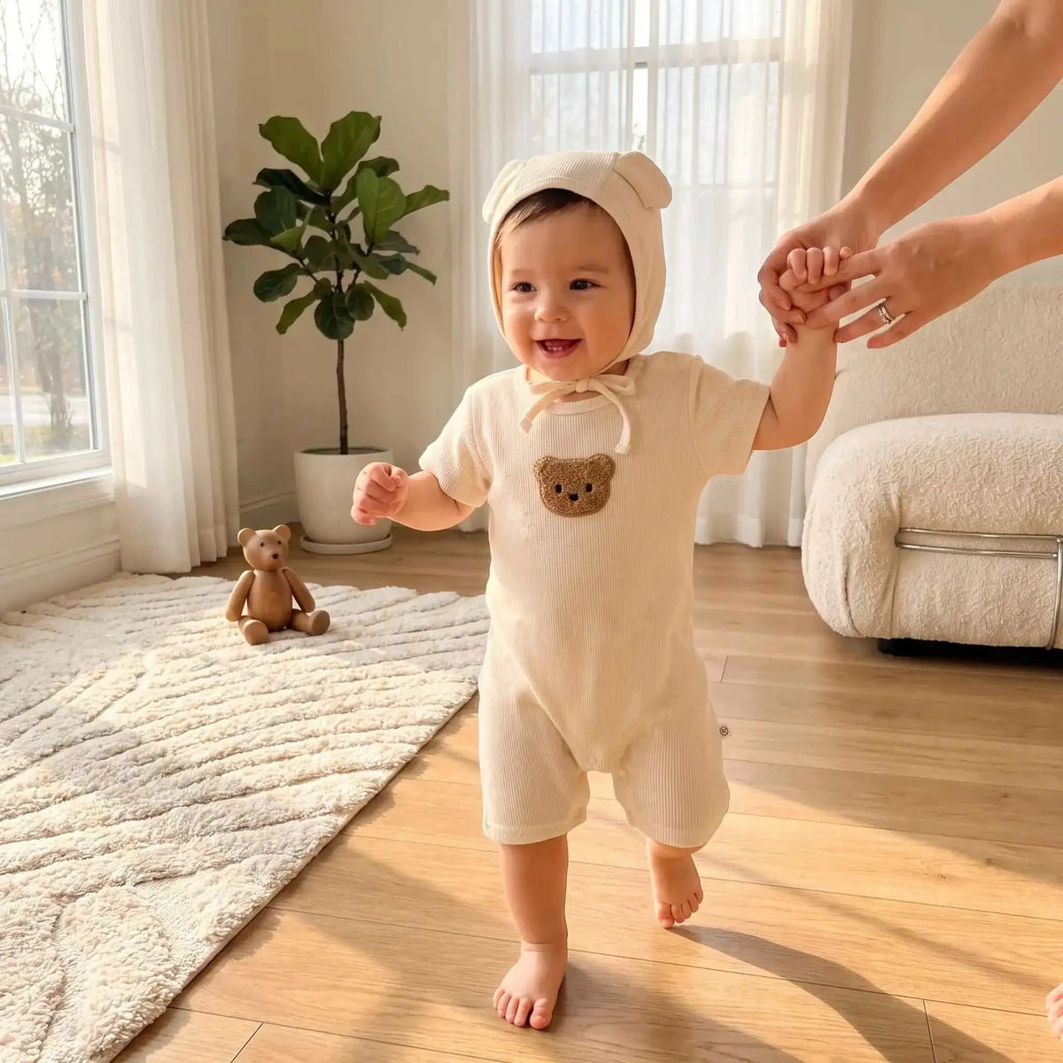 Pyjama bébé garçon écru en tissu côtelé, à manches courtes, avec capuche à oreilles et ourson brodé sur le devant.