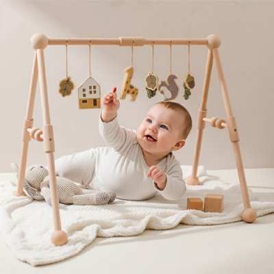 bébé sur le ventre jouant avec son arche d'éveil 