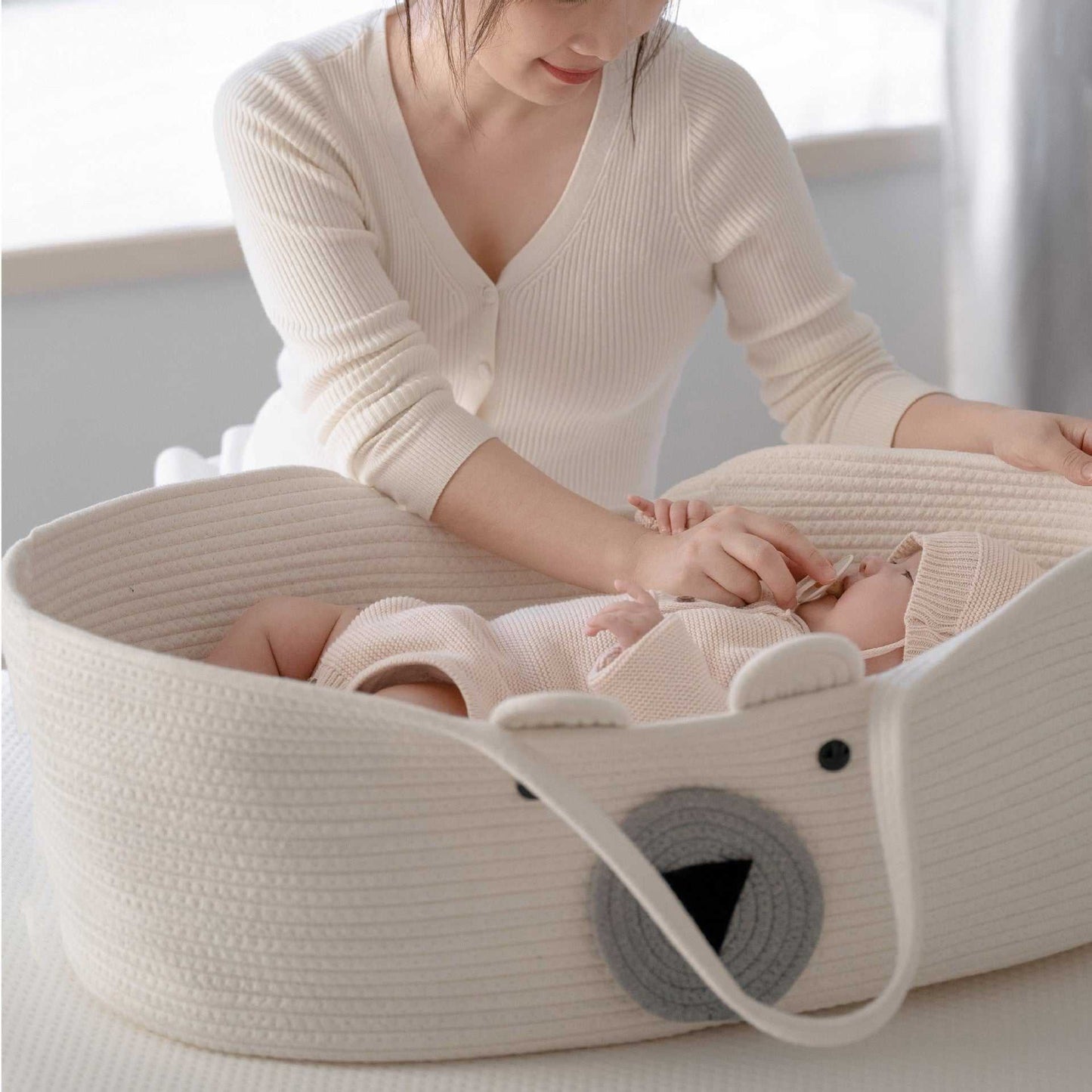 Maman assise prés de bébé dort paisiblement dans son cocon bébé 