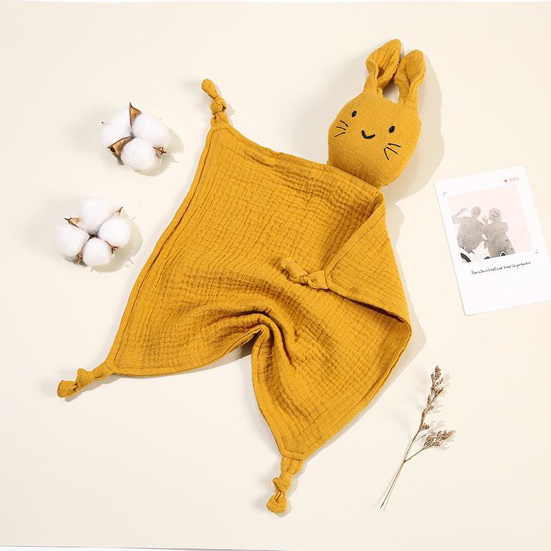 doudou bébé en mousseline de coton doux idéal pour petites mains, visage brodé et couleurs pastel moutarde.