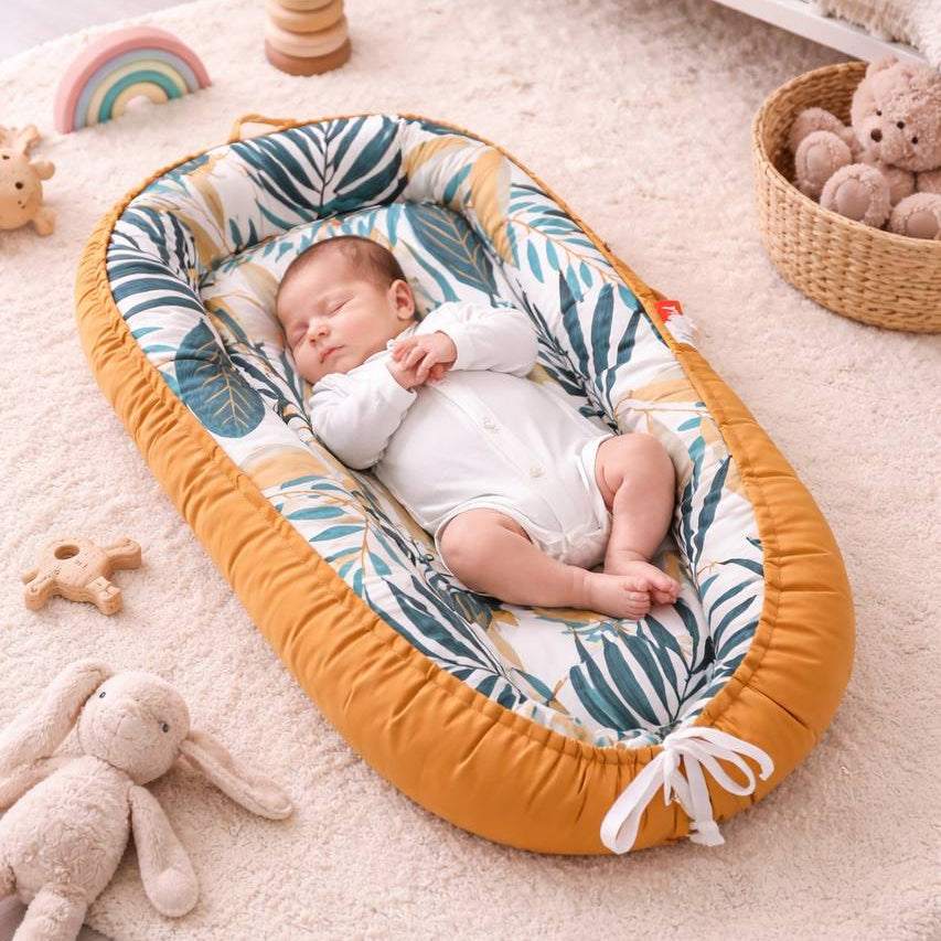enfant dormant dans son nid pour bebe sur un tapis