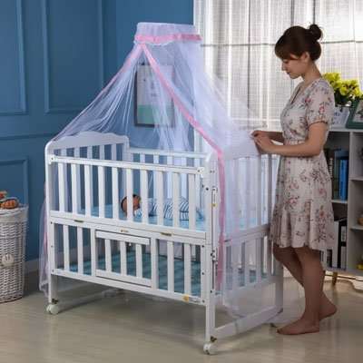 maman a coter du Moustiquaire lit bébé rose