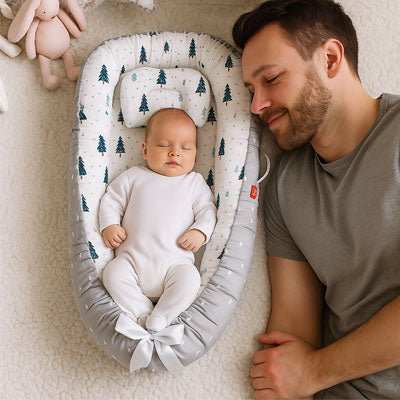 papa a cote de bébé qui dort dans son reducteur de lit gris